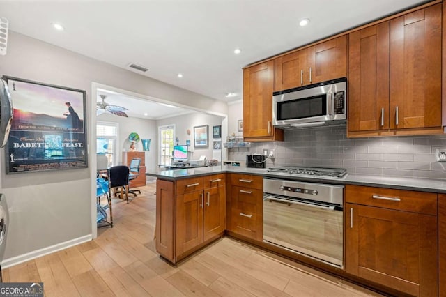 1141 Moorestown Cir, Decatur, GA 30033 - kitchen with stainless steel appliances, a peninsula, brown cabinetry, light wood-style floors, and recessed lighting