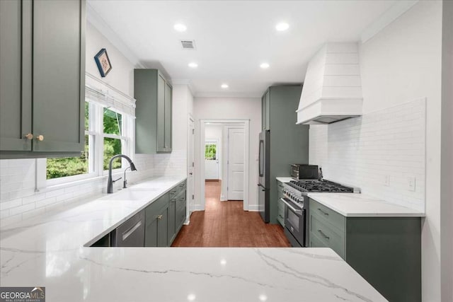 2324 Oakview Rd NE, Atlanta, GA 30317 - kitchen with stainless steel appliances, custom range hood, a sink, light stone counters, and tasteful backsplash