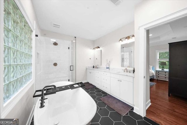 2324 Oakview Rd NE, Atlanta, GA 30317 - full bathroom with a soaking tub, double vanity, a shower stall, connected bathroom, and wood finished floors