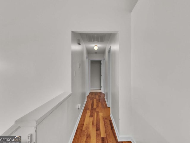 hallway with wood finished floors and baseboards