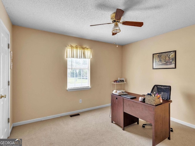 carpeted home office with a ceiling fan, baseboards, and a textured ceiling