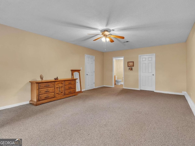 unfurnished bedroom featuring carpet flooring, baseboards, a textured ceiling, and ceiling fan