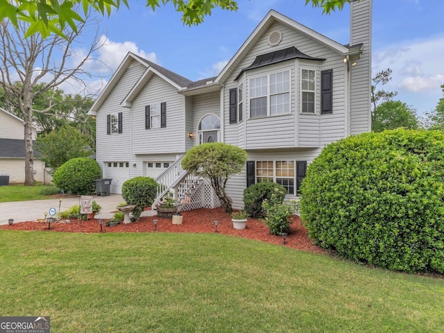 bi-level home with an attached garage, concrete driveway, a chimney, a front yard, and central air condition unit
