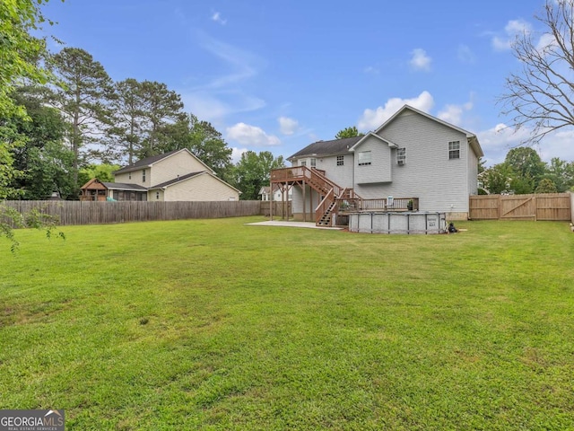 back of property with stairs, a deck, and an outdoor pool