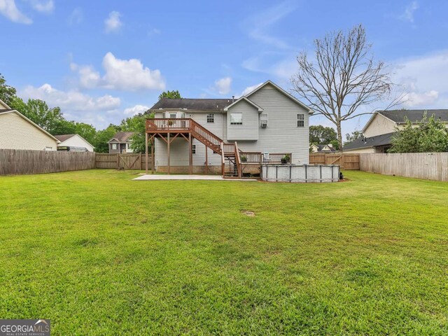 rear view of property with stairs, a wooden deck, and a patio area