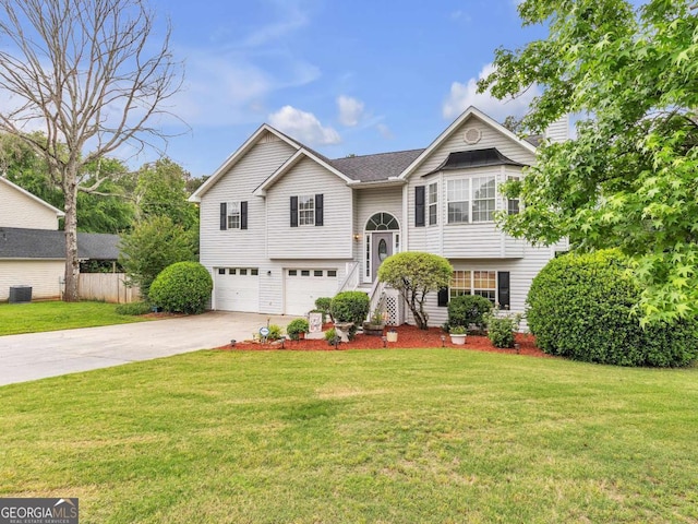 bi-level home with an attached garage, driveway, and central air condition unit