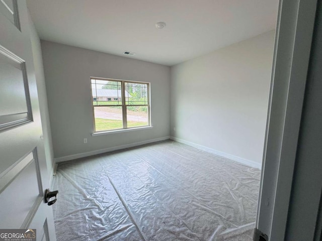 spare room with carpet and baseboards