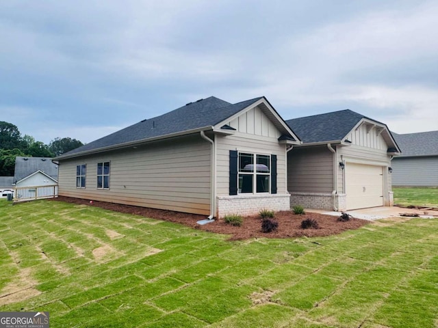 view of side of property featuring board and batten siding, a yard, and brick siding