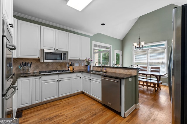 1377 Downington Ln NW, Acworth, GA 30101 - kitchen with stainless steel appliances, a sink, a chandelier, a peninsula, and white cabinets