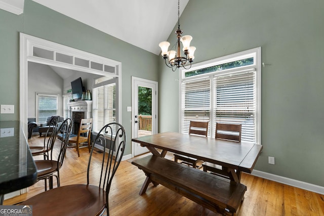 1377 Downington Ln NW, Acworth, GA 30101 - dining room with a chandelier, healthy amount of natural light, a fireplace, baseboards, and high vaulted ceiling