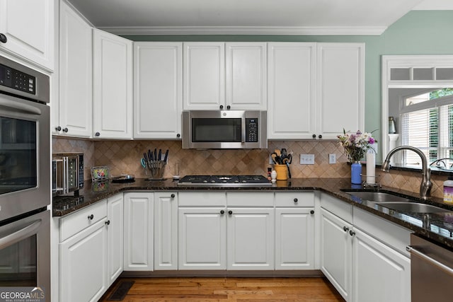 1377 Downington Ln NW, Acworth, GA 30101 - kitchen with appliances with stainless steel finishes, a sink, white cabinetry, crown molding, and tasteful backsplash