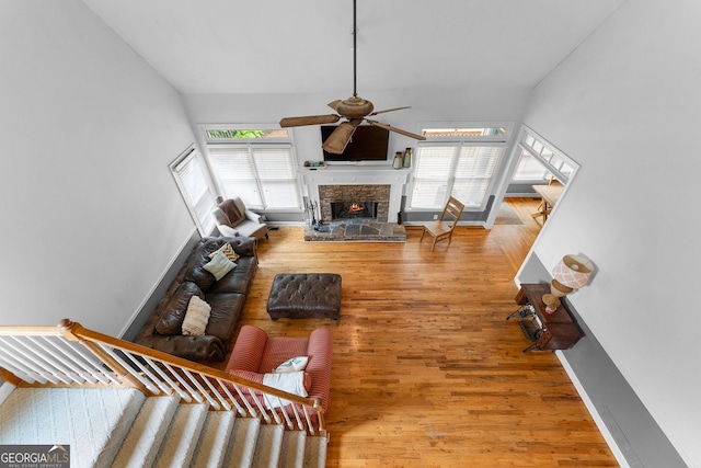 1377 Downington Ln NW, Acworth, GA 30101 - living room featuring ceiling fan, stairs, a fireplace, wood finished floors, and baseboards