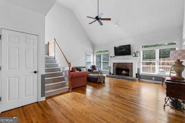 1377 Downington Ln NW, Acworth, GA 30101 - living area with high vaulted ceiling, ceiling fan, wood finished floors, stairs, and a stone fireplace