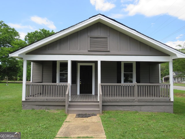 2 4th St, Cedartown, GA 30125 - view of front of home with covered porch, board and batten siding, and a front lawn