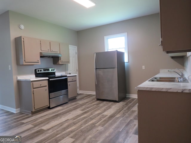 2 4th St, Cedartown, GA 30125 - kitchen with stainless steel appliances, under cabinet range hood, a sink, light countertops, and baseboards
