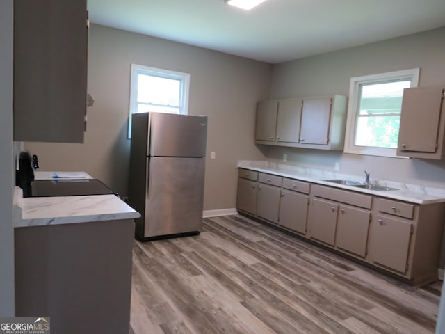 2 4th St, Cedartown, GA 30125 - kitchen with freestanding refrigerator, a sink, light wood-style floors, gray cabinets, and light countertops