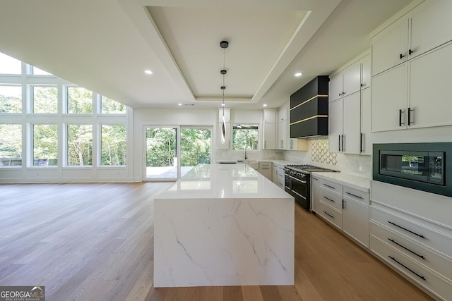 972 Auburn Rd, Dacula, GA 30019 - kitchen featuring range with two ovens, black microwave, healthy amount of natural light, a center island, and recessed lighting