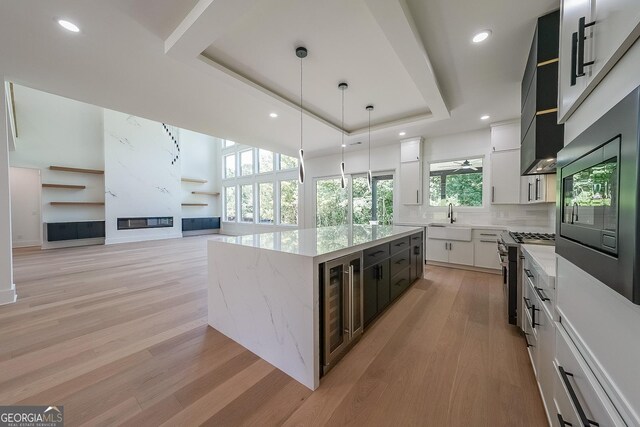 972 Auburn Rd, Dacula, GA 30019 - kitchen with a sink, high end stainless steel range oven, beverage cooler, light wood-type flooring, and backsplash