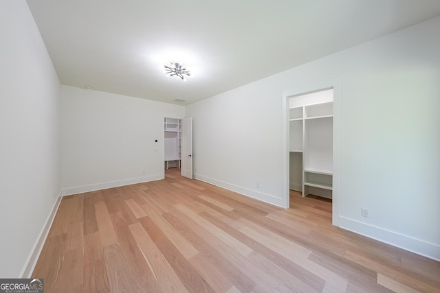 972 Auburn Rd, Dacula, GA 30019 - unfurnished bedroom featuring a walk in closet, light wood-style flooring, and baseboards