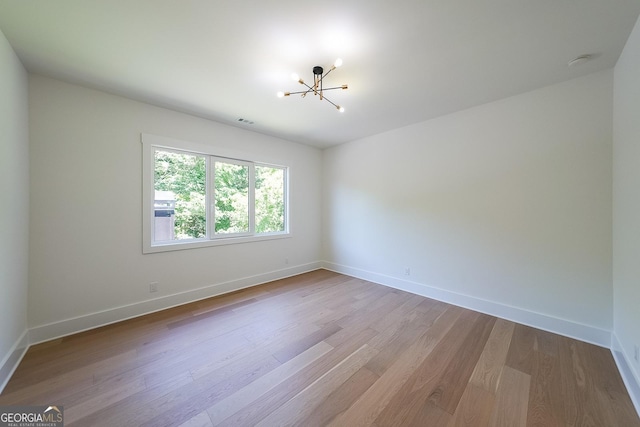 972 Auburn Rd, Dacula, GA 30019 - unfurnished room with a chandelier, wood finished floors, baseboards, and a smoke detector