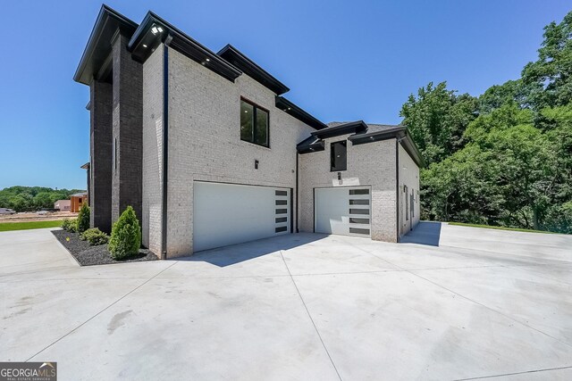 972 Auburn Rd, Dacula, GA 30019 - view of property exterior featuring driveway, a garage, and brick siding