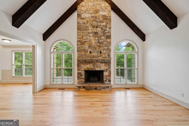 300 Hemlock Cv, Ball Ground, GA 30107 - unfurnished living room with high vaulted ceiling, beamed ceiling, wood finished floors, plenty of natural light, and baseboards