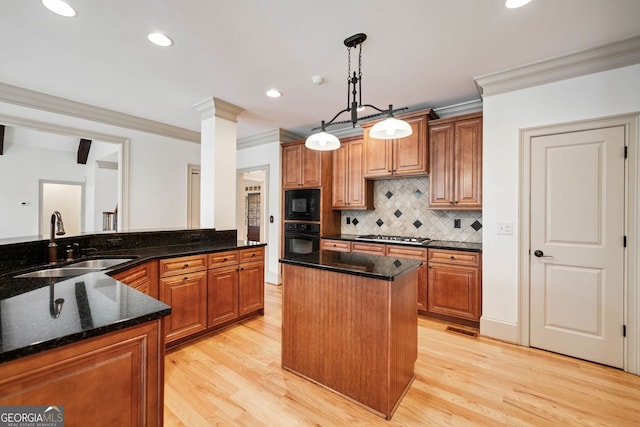 kitchen featuring a sink, black appliances, light wood-style flooring, tasteful backsplash, and crown molding