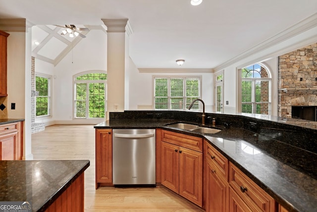 kitchen featuring a sink, dishwasher, light wood finished floors, open floor plan, and ornamental molding