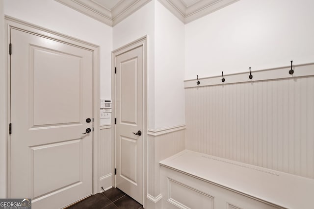 mudroom featuring ornamental molding, wainscoting, and dark tile patterned floors