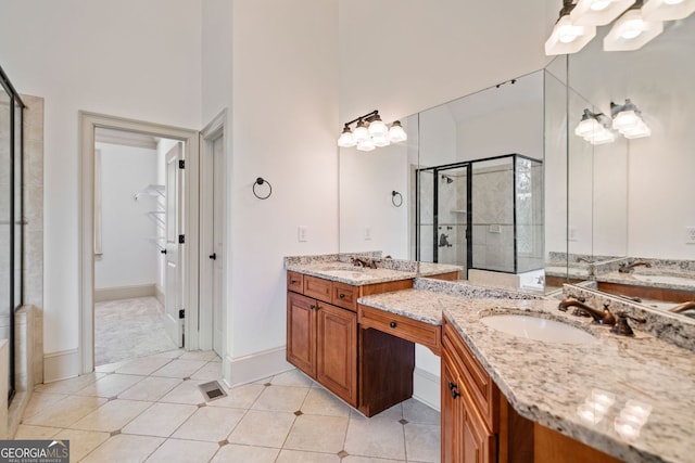 bathroom featuring a stall shower, two vanities, and tile patterned flooring