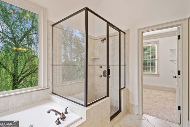 bathroom with a stall shower, tile patterned floors, a jetted tub, and baseboards