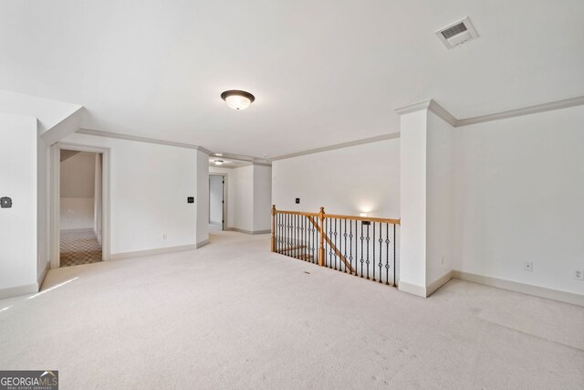 carpeted empty room with baseboards and crown molding