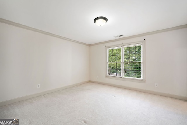 carpeted empty room featuring ornamental molding and baseboards