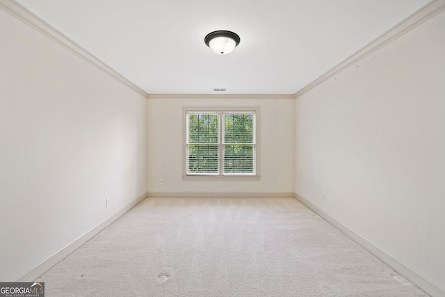 carpeted empty room featuring ornamental molding and baseboards