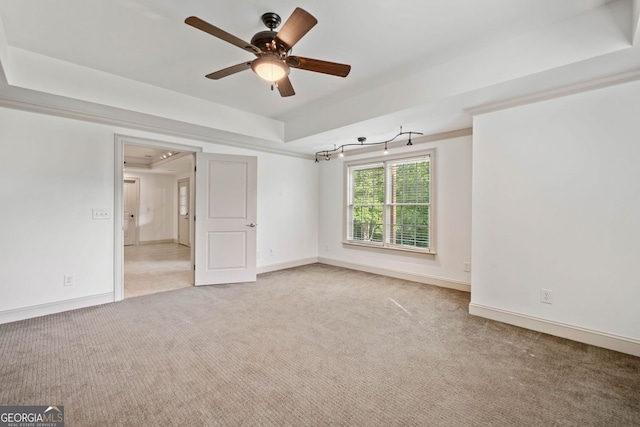 empty room featuring light colored carpet, a ceiling fan, and baseboards