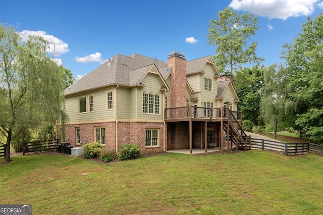back of house featuring brick siding, a wooden deck, a patio area, stairs, and a chimney