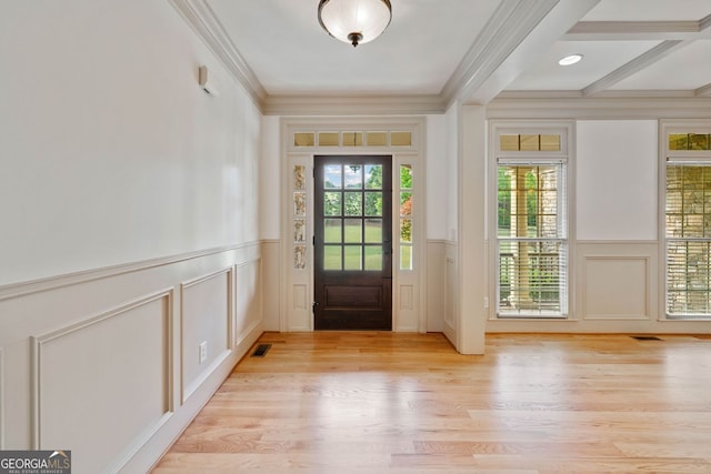 entryway with a decorative wall, a wainscoted wall, light wood finished floors, and crown molding