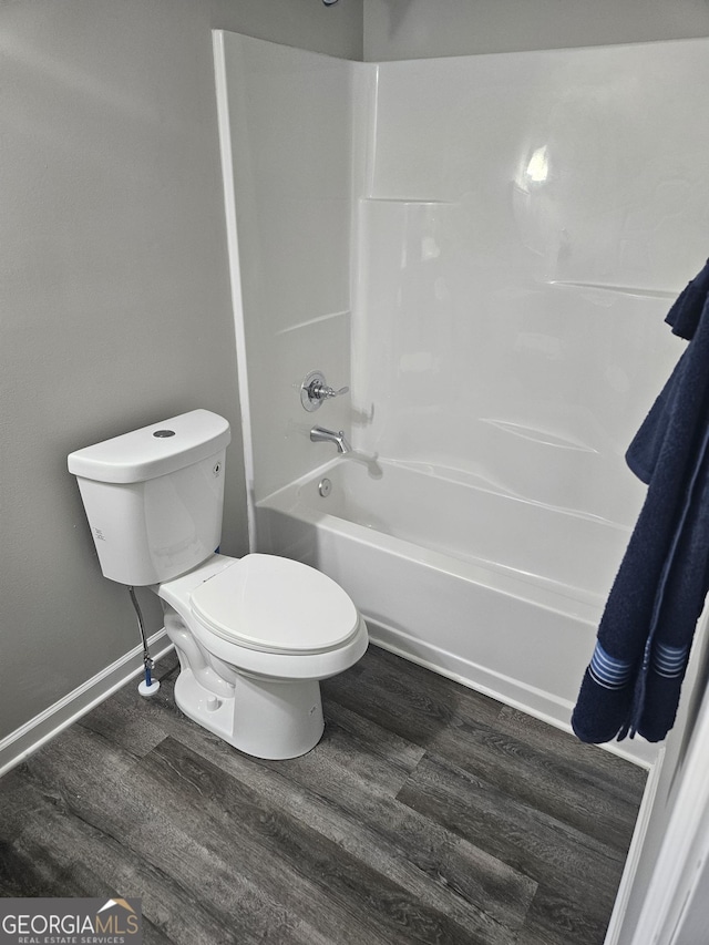 414 E 17th St SW, Rome, GA 30161 - bathroom with wood finished floors, toilet, washtub / shower combination, and baseboards