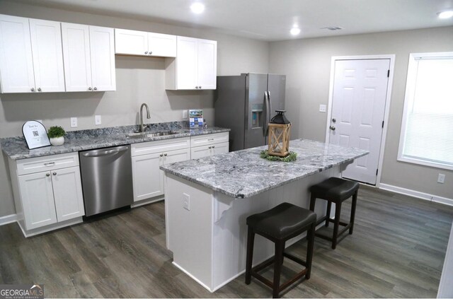 414 E 17th St SW, Rome, GA 30161 - kitchen featuring appliances with stainless steel finishes, a sink, a breakfast bar, a kitchen island, and white cabinetry