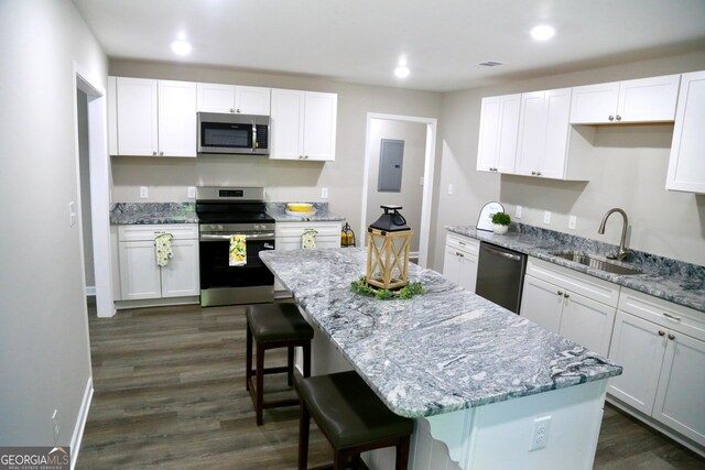 414 E 17th St SW, Rome, GA 30161 - kitchen featuring appliances with stainless steel finishes, a sink, a kitchen island, electric panel, and a kitchen breakfast bar