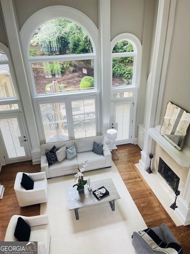 3905 Merriweather Woods, Johns Creek, GA 30022 - living room featuring wood finished floors, a towering ceiling, and a fireplace