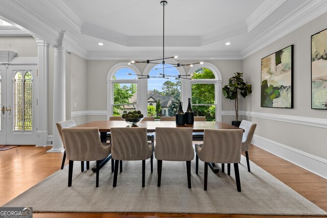 3905 Merriweather Woods, Johns Creek, GA 30022 - dining space with a tray ceiling, a chandelier, ornamental molding, wood finished floors, and decorative columns