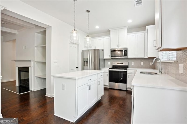 kitchen with stainless steel appliances, a sink, recessed lighting, tasteful backsplash, and dark wood-type flooring