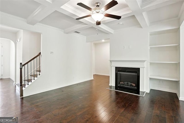 unfurnished living room featuring arched walkways, ceiling fan, coffered ceiling, hardwood / wood-style flooring, and beamed ceiling
