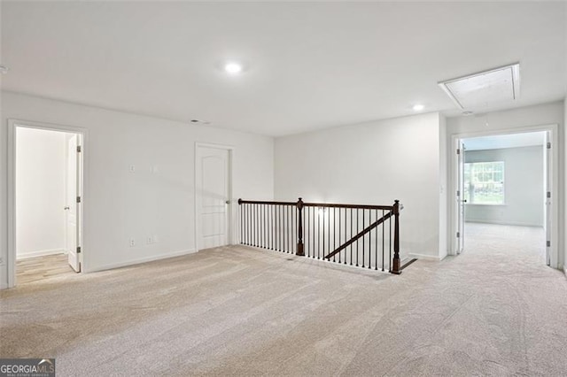 carpeted empty room with attic access, baseboards, and recessed lighting