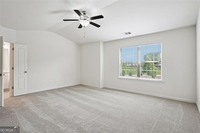 carpeted spare room featuring lofted ceiling, a ceiling fan, and baseboards