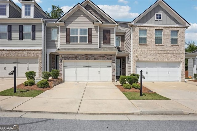 multi unit property featuring an attached garage, concrete driveway, brick siding, and board and batten siding