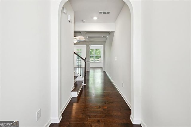 hall featuring arched walkways, wood-type flooring, stairs, baseboards, and coffered ceiling