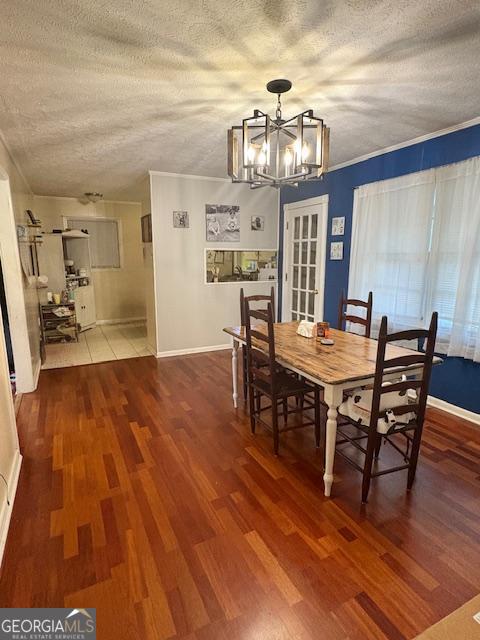 123 Hillview Dr, Thomaston, GA 30286 - dining area with a chandelier, wood finished floors, a textured ceiling, and baseboards