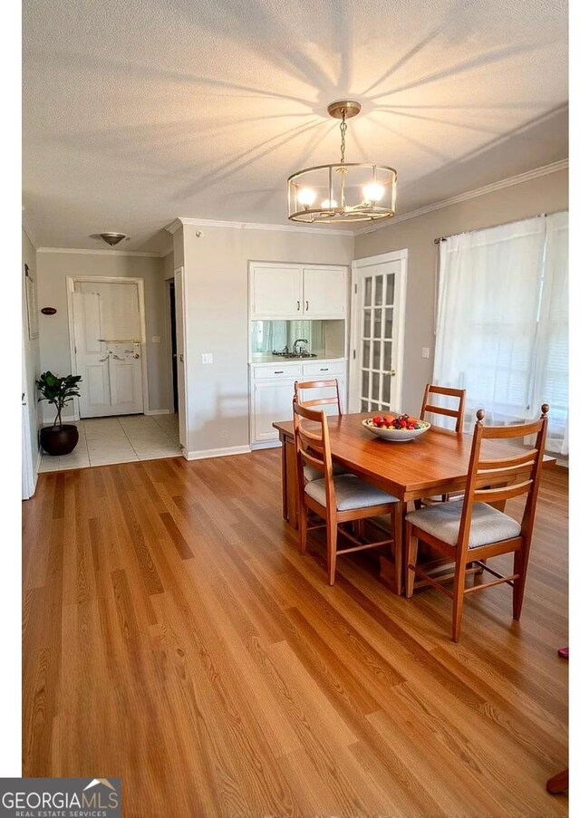 123 Hillview Dr, Thomaston, GA 30286 - dining room featuring a chandelier, light wood-style floors, a textured ceiling, ornamental molding, and baseboards
